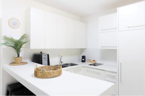 a white kitchen with a basket on a counter at רויאל דרים אילת in Eilat