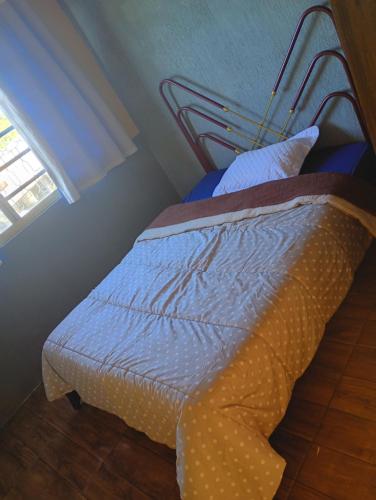 a bed sitting in a room with a window at Casa sobrado in Alegrete