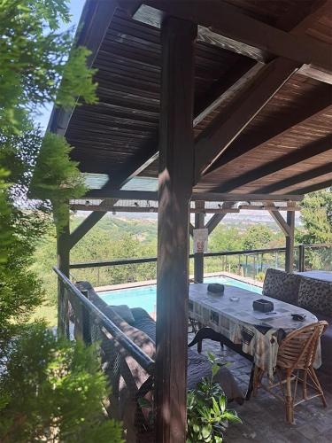 a table and chairs under a wooden pergola at Vila Teja in Ledinci