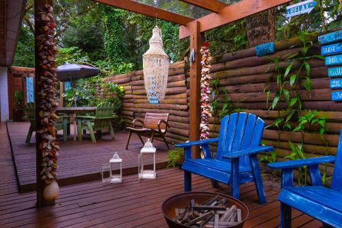 a wooden deck with blue chairs and a chandelier at Pousada e Chalé Lote 22 in Ilha do Mel