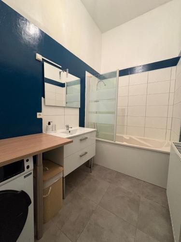 a bathroom with a sink and a tub at Le Cocon de St-Pierre in Calais