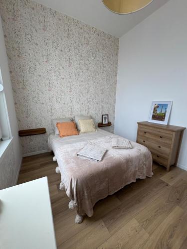 a bedroom with a bed and a wooden floor at Le Cocon de St-Pierre in Calais