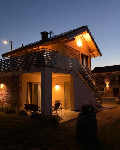 a house with two chairs in front of it at Cascina Ricardin in Coazzolo