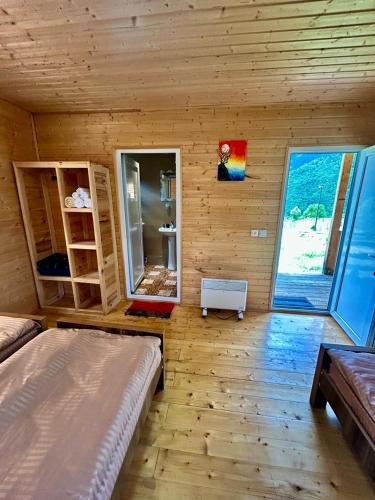 a room with two beds in a wooden room at Ushba Cottages in Mazeri