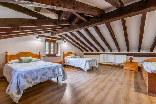 two beds in a room with wooden ceilings at Casa Santa Leocadia in Tama