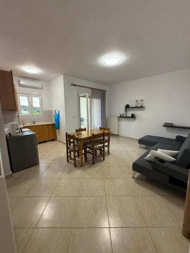 a kitchen and a living room with a table and chairs at Seaside Escape in Nea Peramos