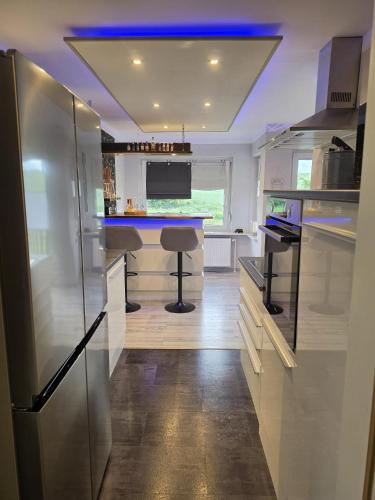 a kitchen with a refrigerator and a bar in it at WoDa's Hütte in Wickerode