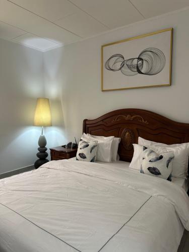 a bedroom with a large bed with white sheets and pillows at Le bungalow by mk in Nzogobeyork