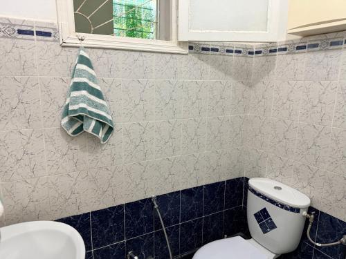 a bathroom with a toilet and a window and a towel at Villa rafraf in Rafrāf