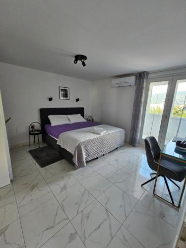 a bedroom with a bed and a table and a chair at Loni in Klenovica