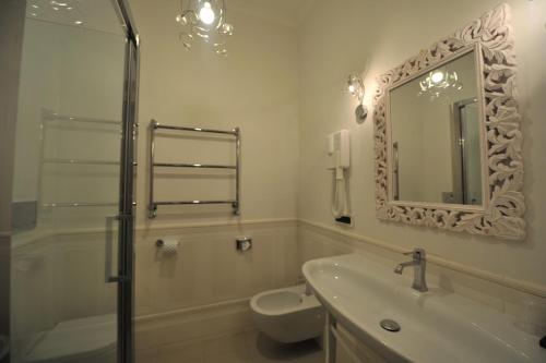 a bathroom with a sink and a toilet and a mirror at Villa Zaccardi in Rome