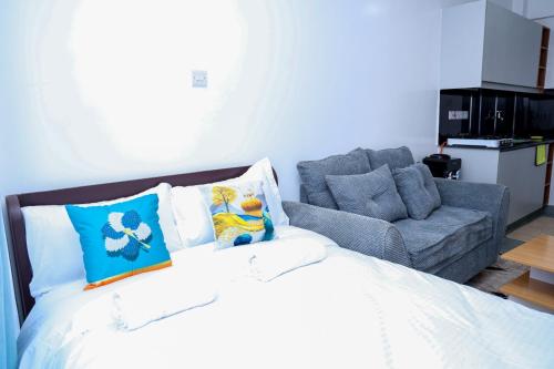 a bedroom with a bed and a couch at Onkundis Luxury Homes in Kiambu