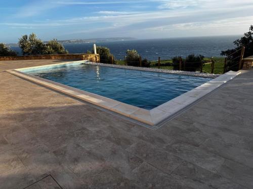 a swimming pool with the ocean in the background at Villa D'aragona Windmill in Għajnsielem