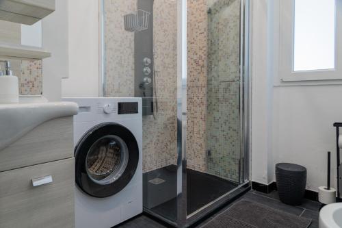 a washing machine in a bathroom with a shower at Casa Flavia in Lierna
