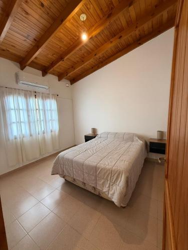 a bedroom with a bed and a wooden ceiling at Alvear Departamento B in Venado Tuerto