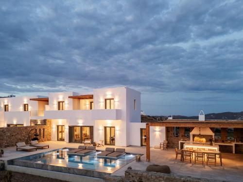 a villa with a swimming pool at night at Vendema Residence Mykonos in Mikonos