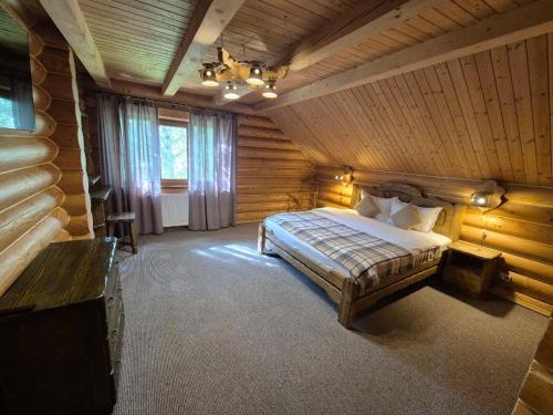 a bedroom with a bed in a log cabin at Княжий двір in Yaremche