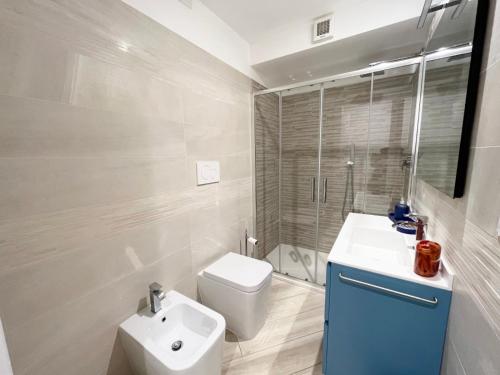 a white bathroom with a toilet and a sink at Jblago in Arona