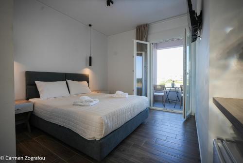 a bedroom with a bed and a view of a balcony at Costa Varda Apartments in Mourteri