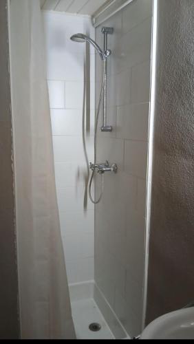 eine Dusche mit Glastür im Badezimmer in der Unterkunft Silver Lotus in De Haan