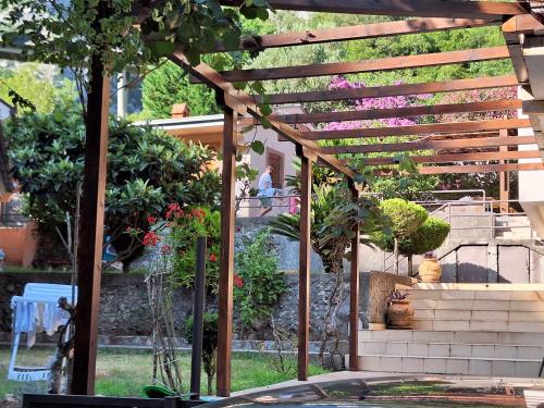 a wooden pergola in a garden with some plants at Salatić-Lekić apartmani in Čanj