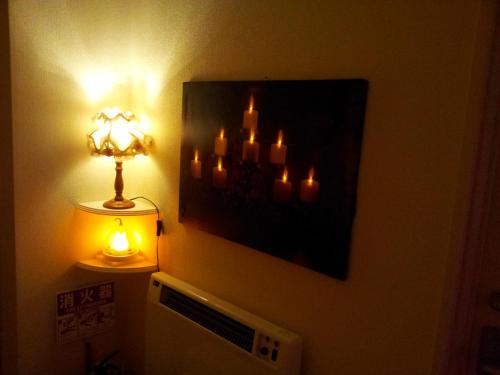 a room with a lamp and a picture of candles at Tokyo8home Hachioji 東京民宿 八王子之家 in Hachioji