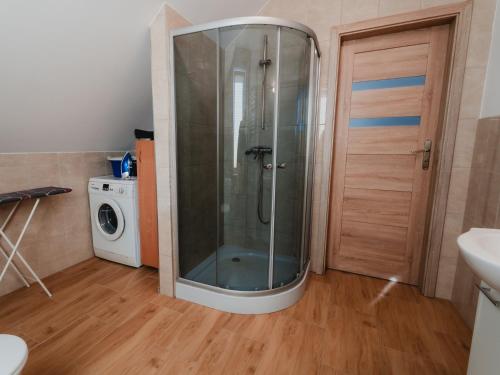a shower in a bathroom with a washing machine at Pokoje Gościnne Wróblówka in Laskowa