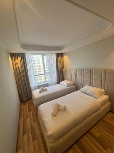 two beds in a room with a window at Hilton Tanger View Tower 15D in Tangier