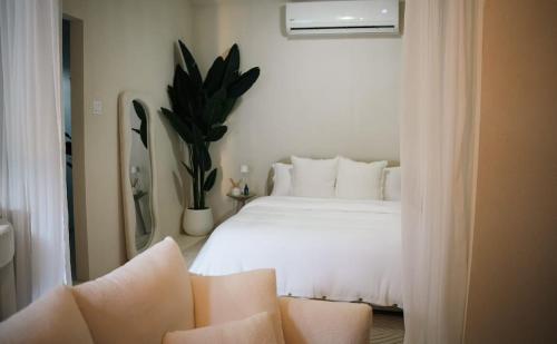 a bedroom with a white bed and a potted plant at Villa Zen - 1 Bedroom Studio in Saint James