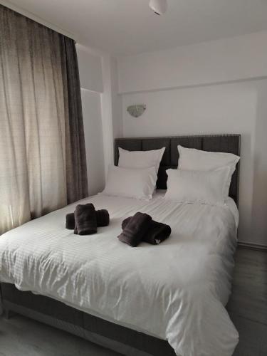 a large white bed with two brown towels on it at Apartament OAȘUL 2 in Hurez
