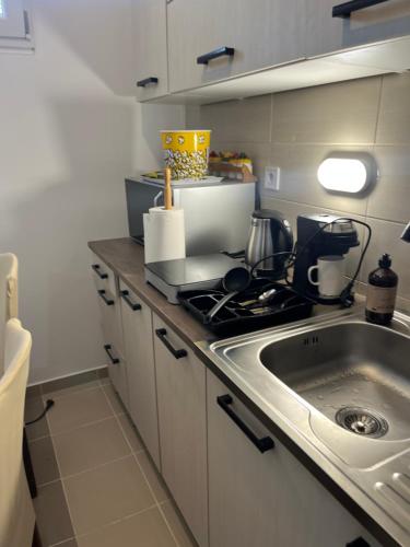 a small kitchen with a sink and a stove at Mazsola apartman in Hódmezővásárhely