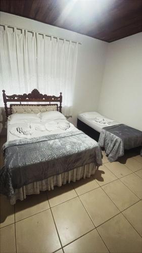 a bedroom with two beds and a window at Sítio Jorema in Camanducaia