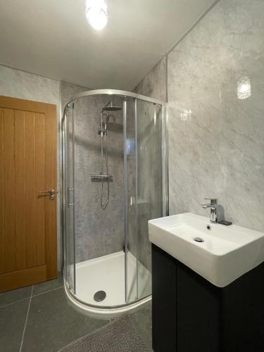 a bathroom with a shower and a sink at CamCosy Retreat in Gortin
