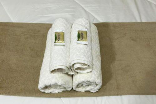 a pile of white towels on a bed at Chalés EduCarMo in Ametista do Sul
