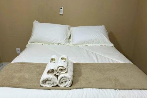 a bed with towels and pillows on it at Chalés EduCarMo in Ametista do Sul