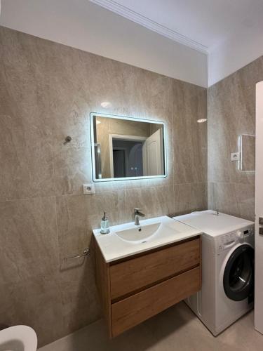 a bathroom with a washing machine and a sink at Saranda Apartments in Sarandë