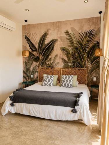 a bedroom with a large bed with plants on the wall at Casa Areka in Brisas de Zicatela
