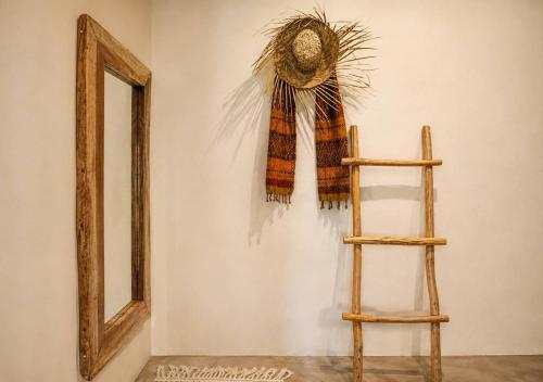 a mirror and a scarf on a wall next to a ladder at Casa Areka in Brisas de Zicatela