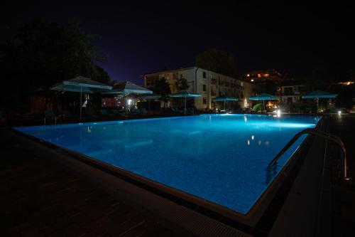 a large swimming pool at night with lights at Q Hotel in Neptun