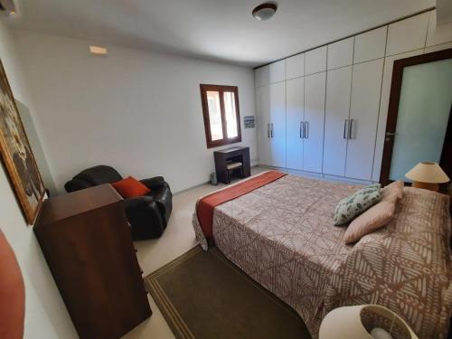 a bedroom with a bed and a chair in it at Spacious Poolside Apartment with Patio 11A2S in Għajnsielem