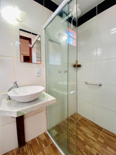 a bathroom with a sink and a glass shower at Pousada São Pedro in Flecheiras