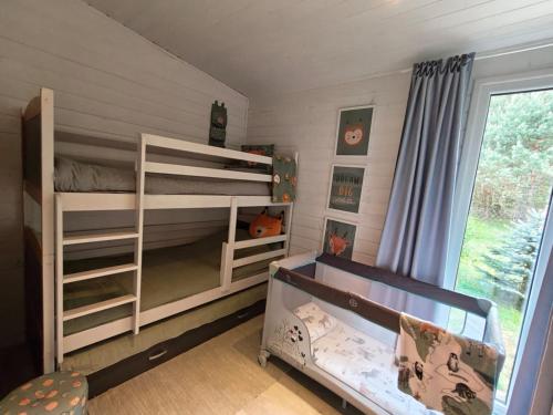 a bedroom with two bunk beds and a window at Stacja Roztocze in Majdan Kasztelański
