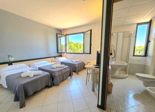 ein Hotelzimmer mit zwei Betten und einem Badezimmer in der Unterkunft GRAN DELTA River & Nature Hotel in Rosolina