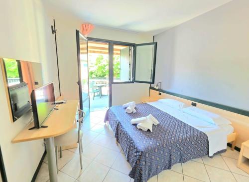 ein Schlafzimmer mit Bett, Schreibtisch und Computer in der Unterkunft GRAN DELTA River & Nature Hotel in Rosolina