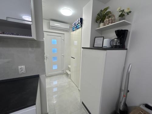 a small kitchen with a white refrigerator and a door at My Miracle Stinica in Stinica