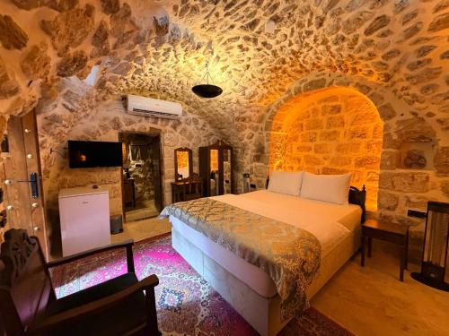 a bedroom with a bed in a stone room at Mirisso Konağı MARDİN in Mardin