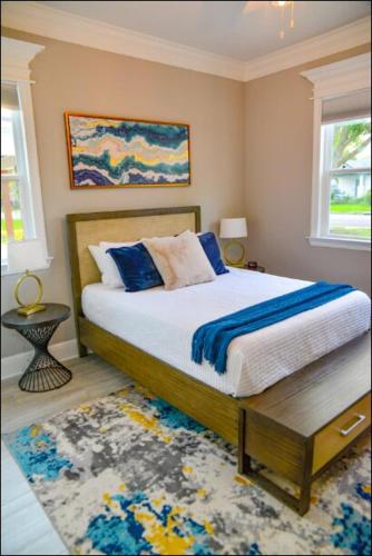 a bedroom with a bed with blue pillows on it at Luxe Dream Beach House in Gulfport