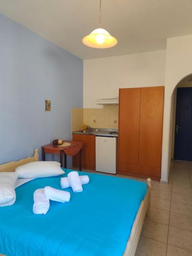 a bedroom with a blue bed with towels on it at Deilino - Olive View Studio in Amorgos