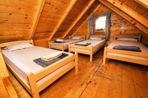 three beds in a room in a log cabin at SmallGrin Ada Bojana in Ulcinj