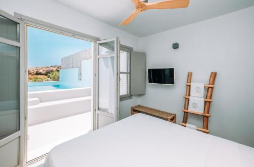 a bedroom with a bed and a large window at Thimari Lodge in Fira